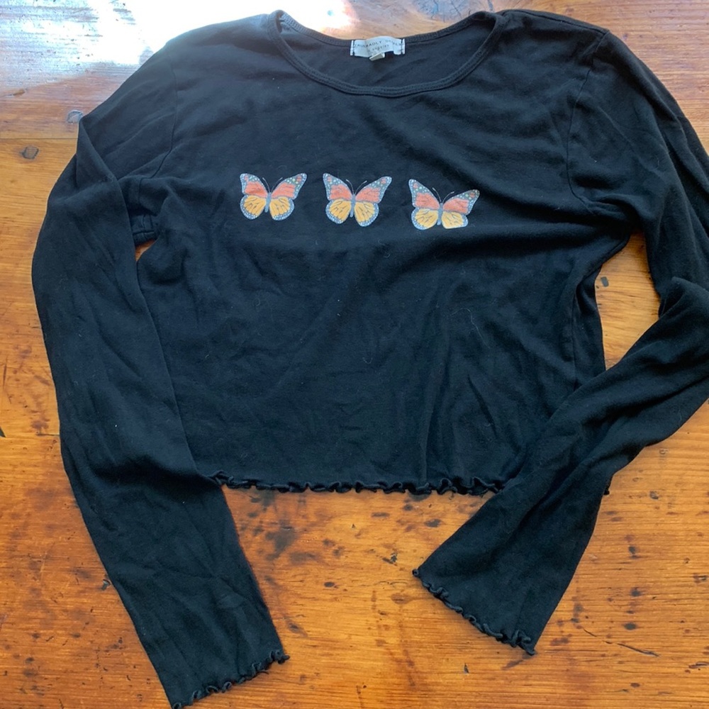 Black cropped t-shirt with butterfly embellishments and lettuce edges.